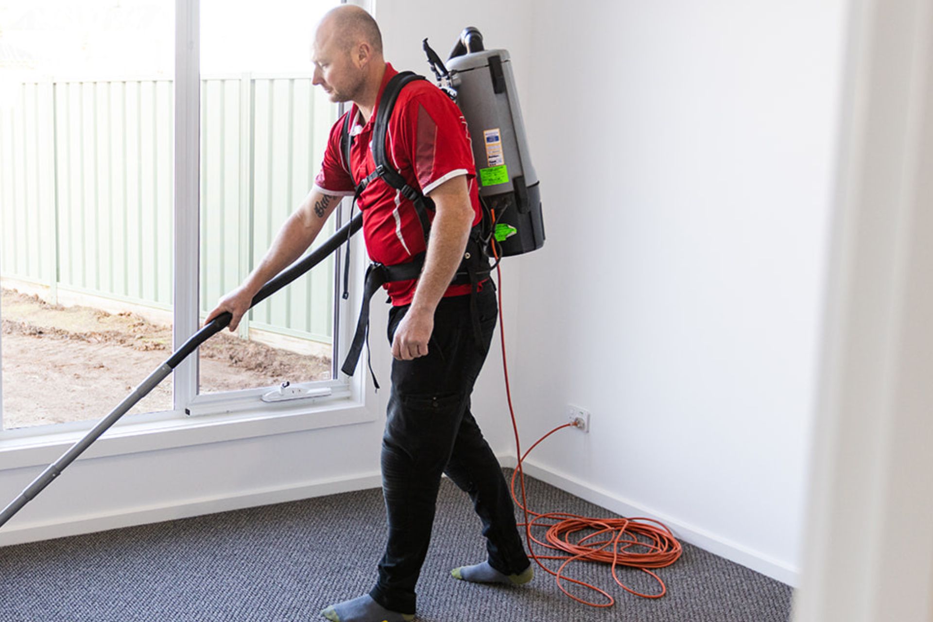 Professional cleaner vacuuming office carpet during commercial cleaning service in Victoria