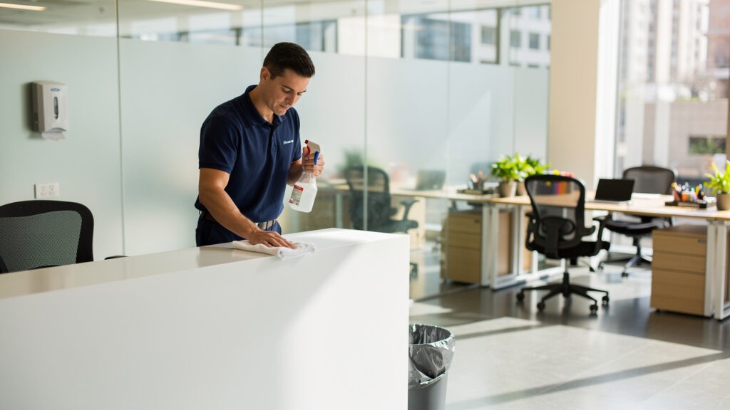Professional cleaner sanitising surfaces in modern Australian office
